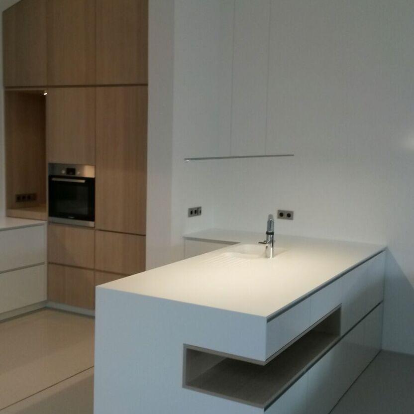 Kücheninsel mit Design-Ablage Moderne Kücheninsel mit Spüle, offenen Regalfächern und Hängelampe im Hintergrund