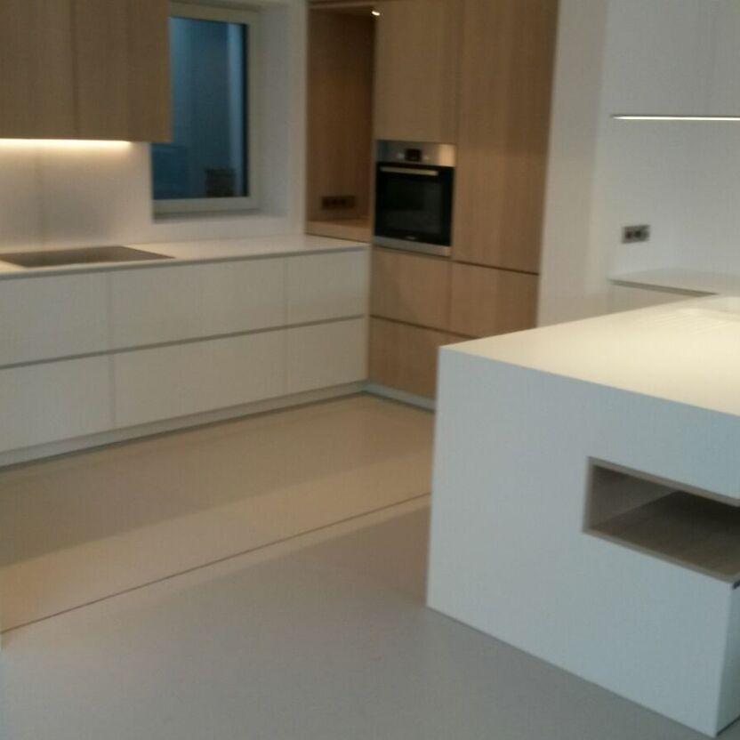 Offene Küche mit Kochinsel Helle Küche mit weißer Kochinsel, Holzhochschränken und eingelassenem Fenster