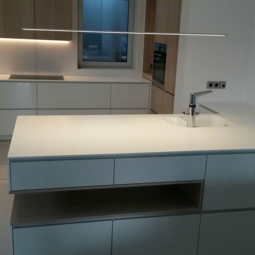 Kochinsel mit Spüle und Lichtleiste Moderne Kücheninsel mit Spüle, weißen Fronten und schwebender LED-Leuchte