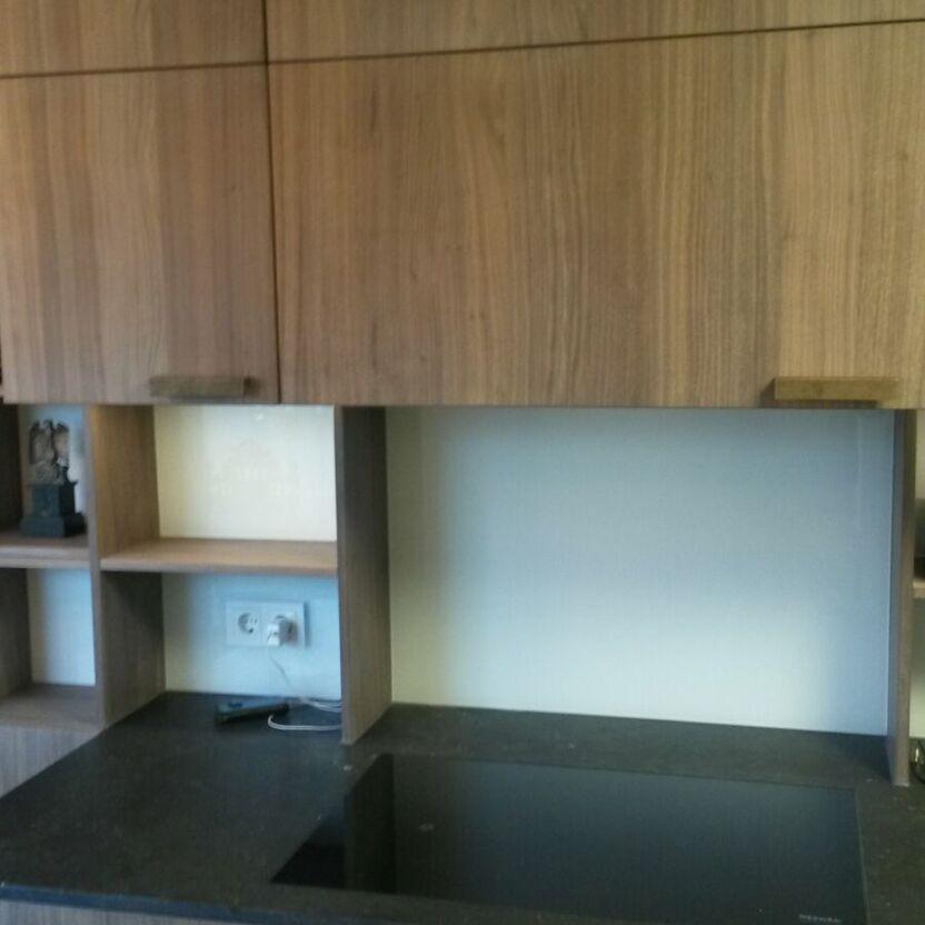 Holzküche mit Kochfeldnische Küchenzeile mit Holzfronten, schwarzem Kochfeld und offener Nische mit Steckdose