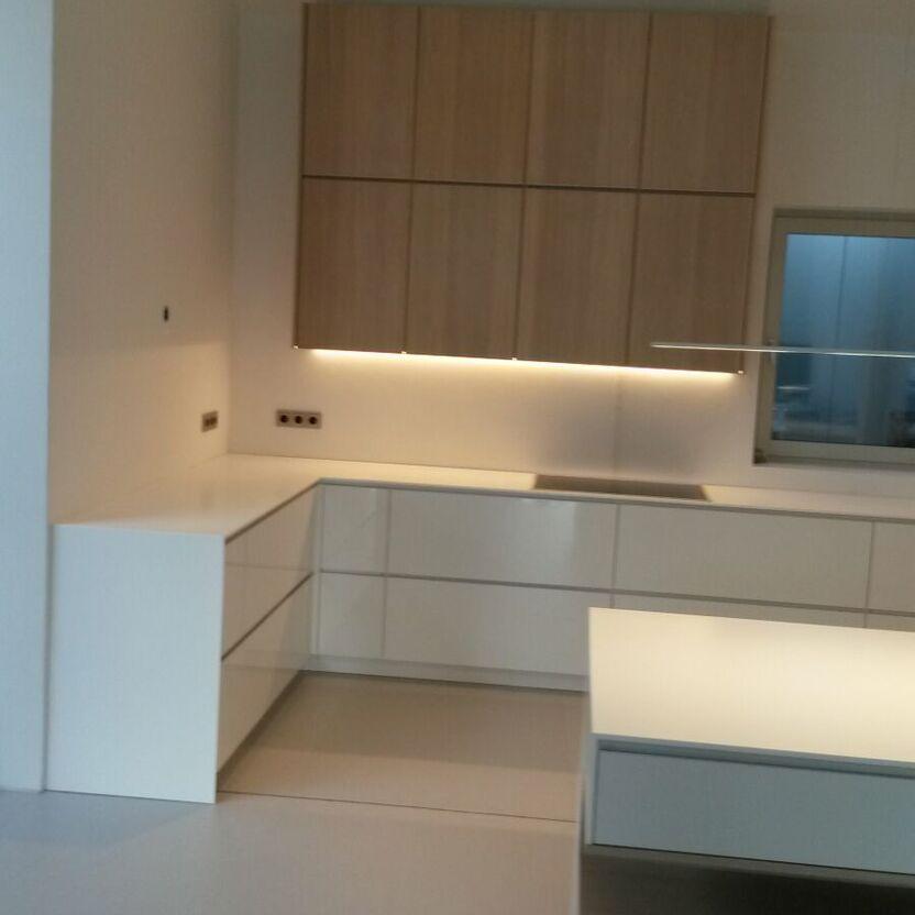 Weiße Küche mit Holzdetails L-förmige Küche mit weißen Unterschränken, Holzoberschränken und heller Kochinsel