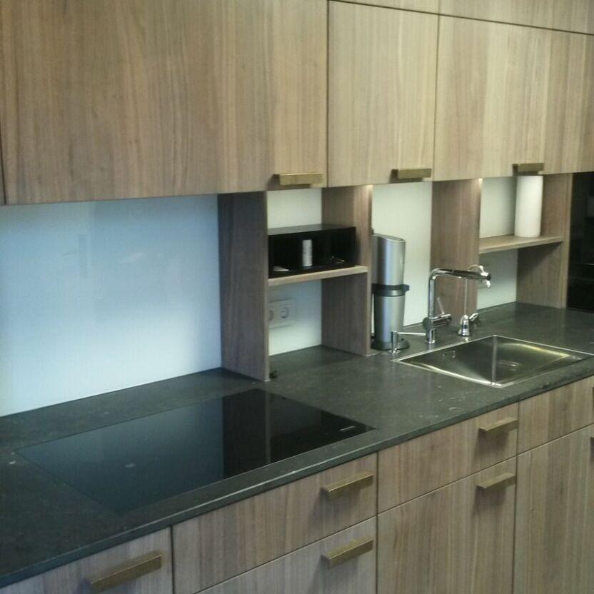 Küche mit Holzfronten und Nischen Küchenzeile mit dunkler Arbeitsplatte, Holzfronten und offenen Nischenfächern