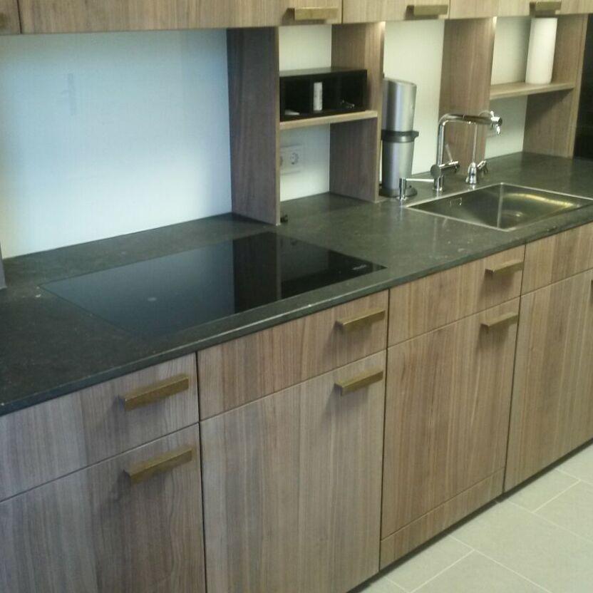 Küchenzeile mit Holz und Schwarz Küche mit Holzfronten, dunkler Arbeitsfläche, Kochfeld und Spüle mit Armatur