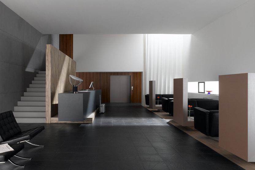 Hotelappartment Untergeschoss mit Holzmobiliar, dunklem Parkett und Treppenaufstieg