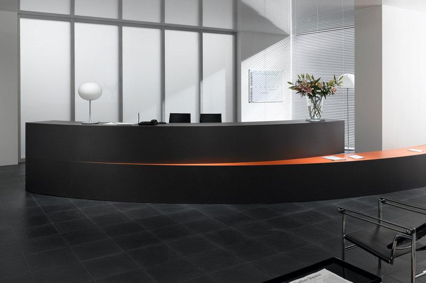 Hotelrezeption mit schwarz lackierter Empfangstheke und orangenem Kontrast