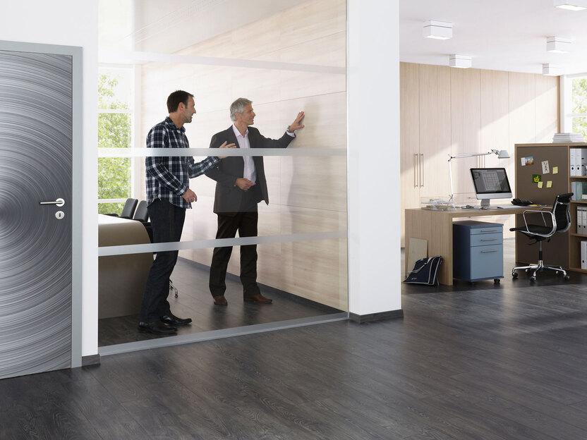 Impression eines Büros mit abgeschlossenem Raum. Impression eines Büros mit abgeschlossenem Raum mit Glaswand und offener Bürogestaltung.