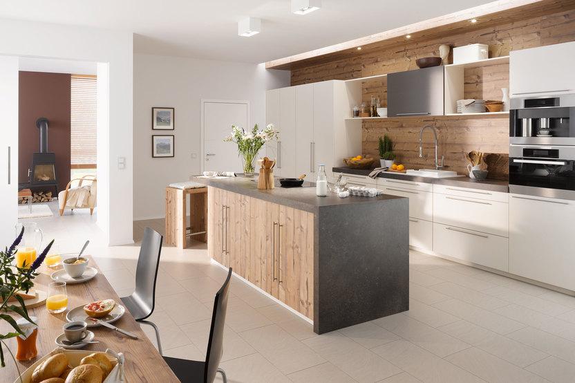 Impressionen einer Küche mit Esszimmer mit hellen Holzmöbeln und dunklen und weißen Fronten im Kontrast